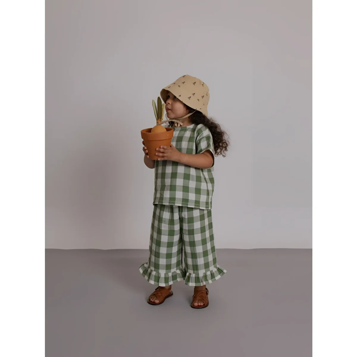 Kleines Kind in Dill Gingham Boxy T-Shirt, grün-weiß Karo, Rüschen, Hut, Sandalen