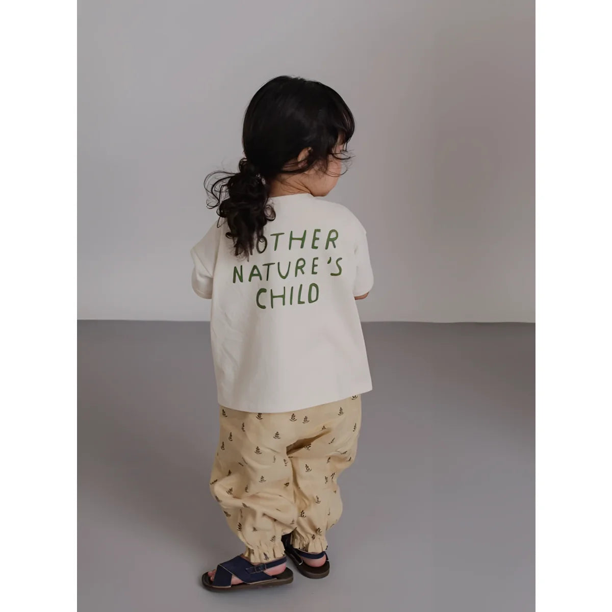 Rückseite: Kind in beigefarbenem Boxy T-Shirt Mother Nature’s Child