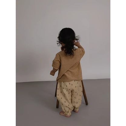 Kind auf Holzstuhl in Boxy T-Shirt Wheat Terry mit Baum-Muster