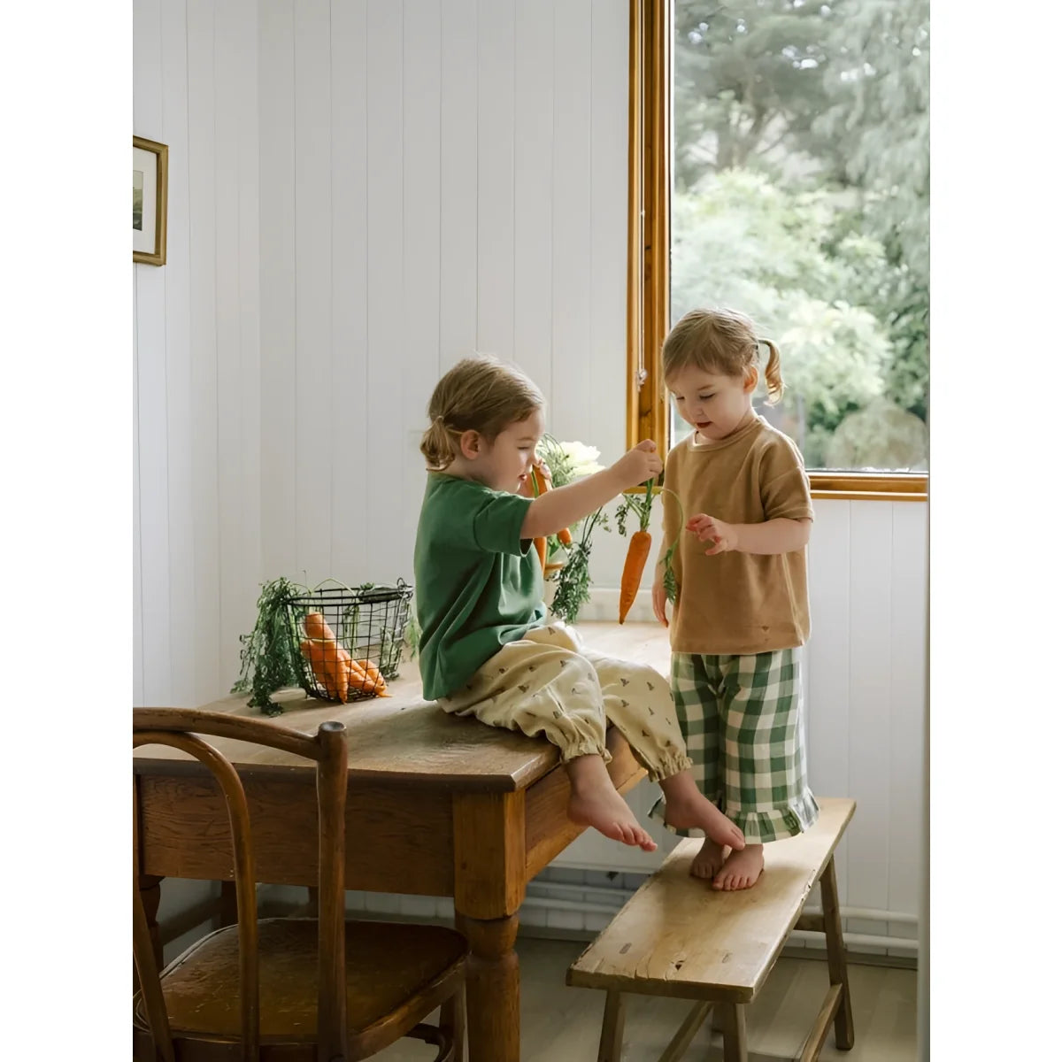 Zwei Kinder in Boxy T-Shirt Wheat Terry auf Holztisch und Bank