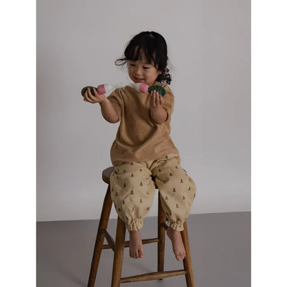 Boxy T-Shirt Wheat Terry: Kind in beigem Top und grüner Baumhose