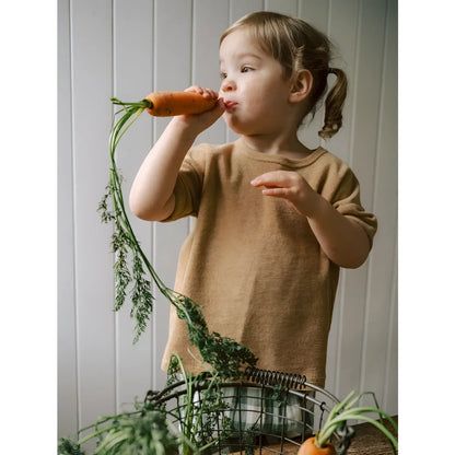 Kleines Kind hält frische orange Karotte mit langen grünen Blättern, Boxy T-Shirt Wheat Terry