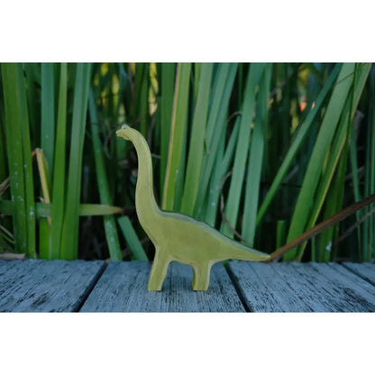 Hellgrüner Brachiosaurus Holzfigur mit langem Hals auf grauer Oberfläche