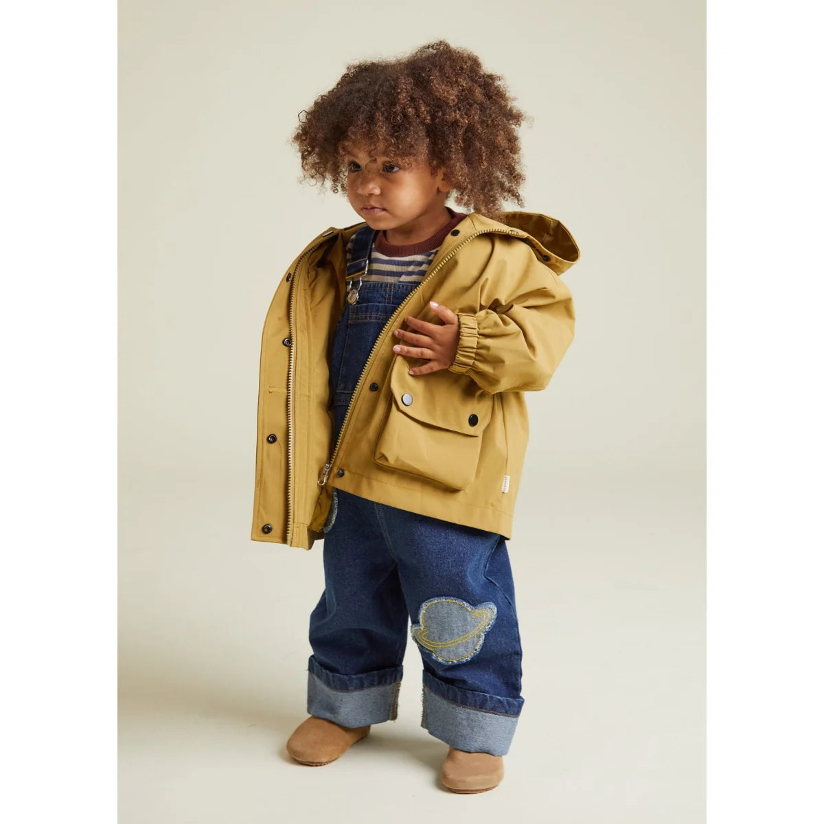 Senfgelber Kapuzen-Regenmantel mit schwarzen Knöpfen und einer Brusttasche