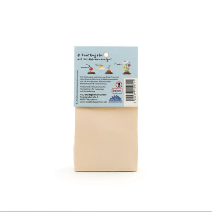 Beige rechteckige samenpackung bunt blumenmurmeln mit blauem etikett und pflanzenillustrationen für ökologische kinderprodukte