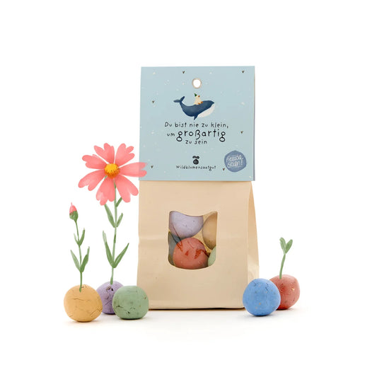 Eine hellblaue und beige papiertüte mit fenster und einem verspielten wal-etikett für ökologische baby- und kinderprodukte