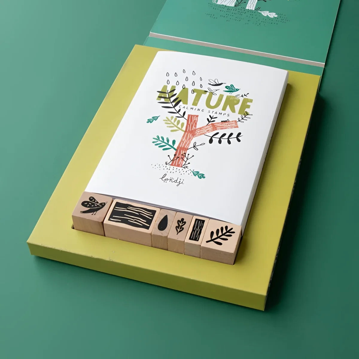 Beruhigende Natur-Stempel aus Holz mit schwarzen Motiven auf gelber Box und Karte