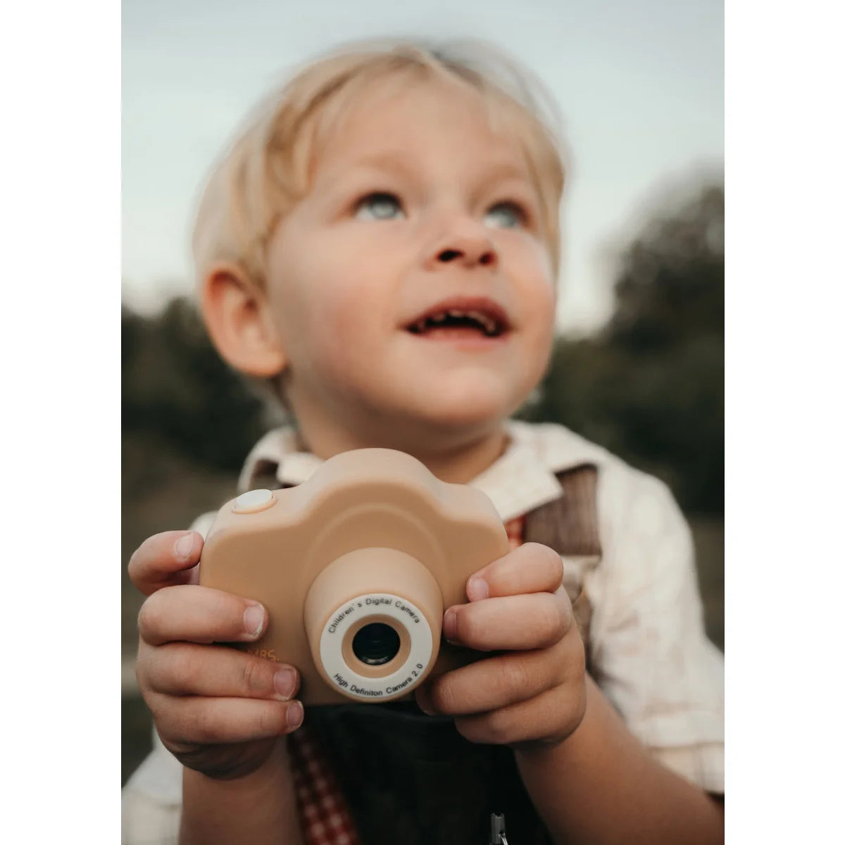 Vintage-beige Digitalkamera in kleinen Händen für kinderfreundliche Fotografie