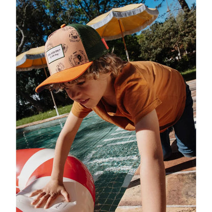 Orange und grüne trucker cap von inkee mit beiger vorderseite und schwarzen illustrationen