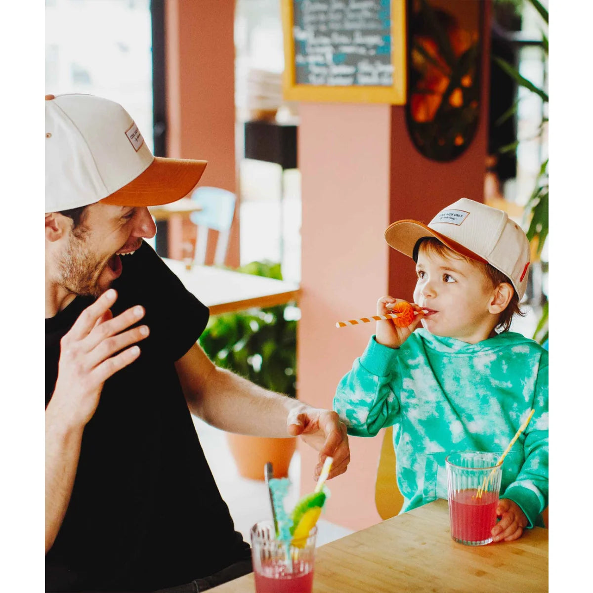 Ein kind trägt eine beige und orange cap mini mit kleinem rechteckigem patch vorne