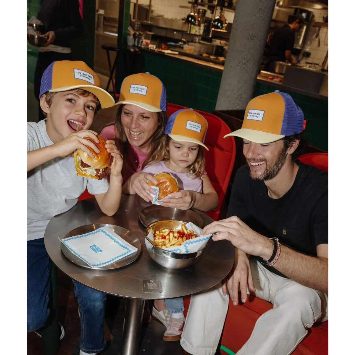 Orange und blaue trucker-mütze mit weißem etikett vorne im modell cap mini canyon