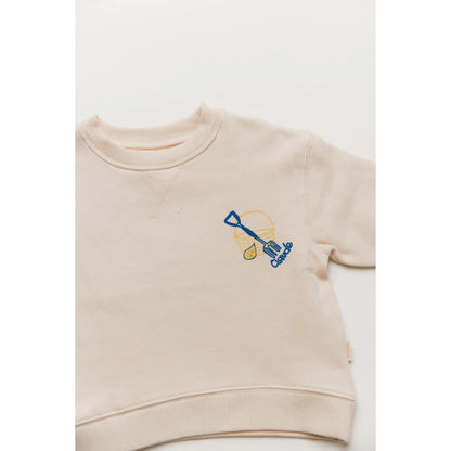 Beiger kindersweatshirt carner grow slowly mit blau gelbem besticktem schaufelmotiv auf der brust
