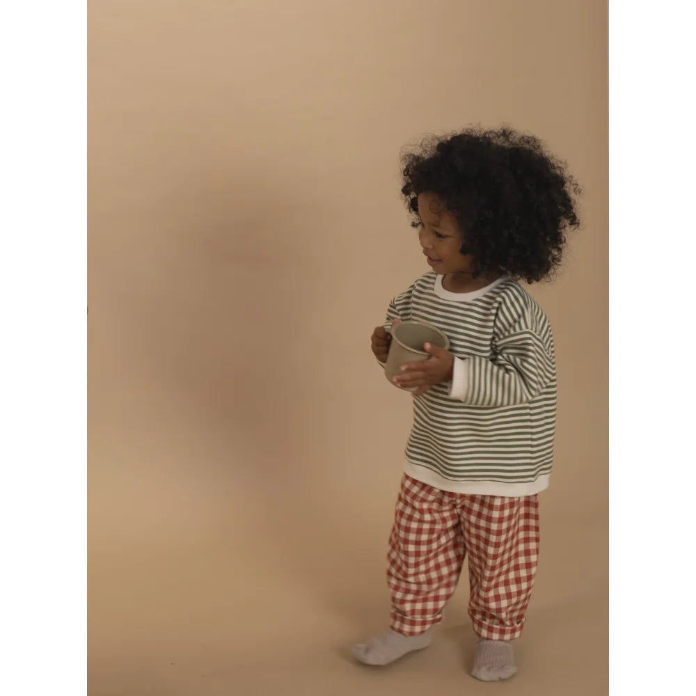Kleinkind in gestreiftem Hemd und Karo-Hosen hält eine Tasse, Carrot Pants Paprika Gingham