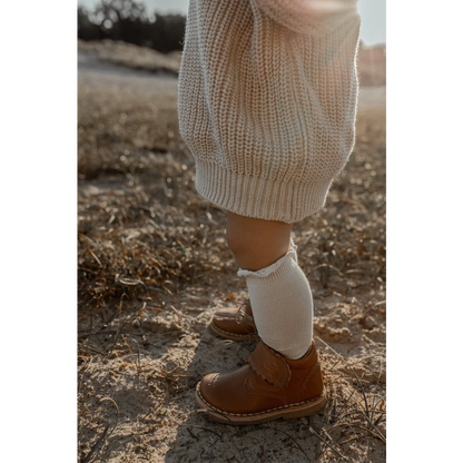 Braunes Leder-Ankle-Boot kombiniert mit weißer Socke und cremigem Pullover