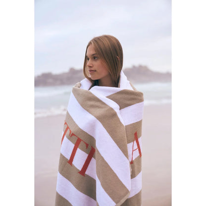 Beige und weiss gestreiftes ciaobadetuch mit roten buchstaben ideal für ökologische baby- und kinderprodukte am strand