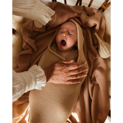 Schlafender neugeborener Säugling gähnt in einer Kuscheldecke Cocoon Babydecke Oat