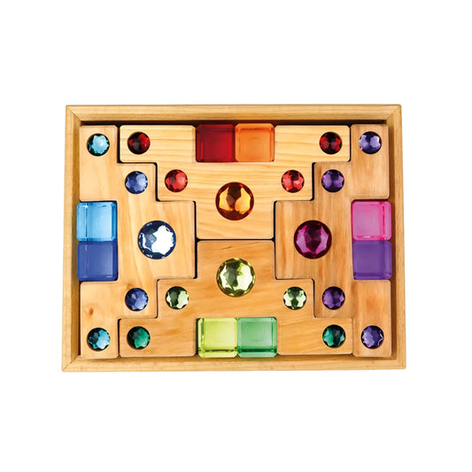 Ein holzkasten mit 16 facettierten farbigen leuchtenden gesteinsblöcken in blau rot grün lila und orange