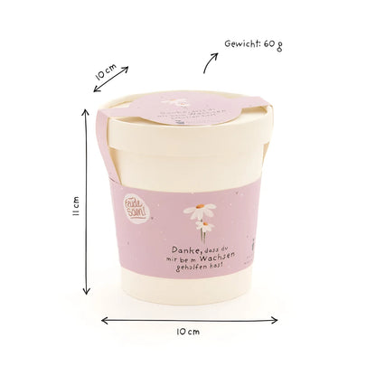 Danke wachsen becher mit pastelrosa und cremefarbener kerze in zylindrischem gefäß mit margeriten für ökologische baby- & kinderprodukte