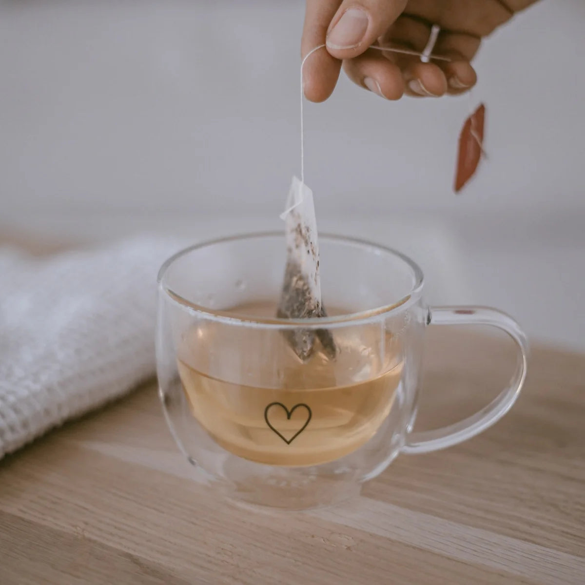 Doppelwandige Glastasse Herz 250ml mit Herz-Design, gefüllt mit Tee und Teesbeutel