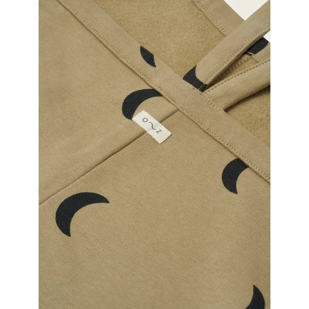 Tan Stoff mit schwarzen Halbmondmustern und kleinem weißen Label für Dungarees Latzhose Dusky Midnight