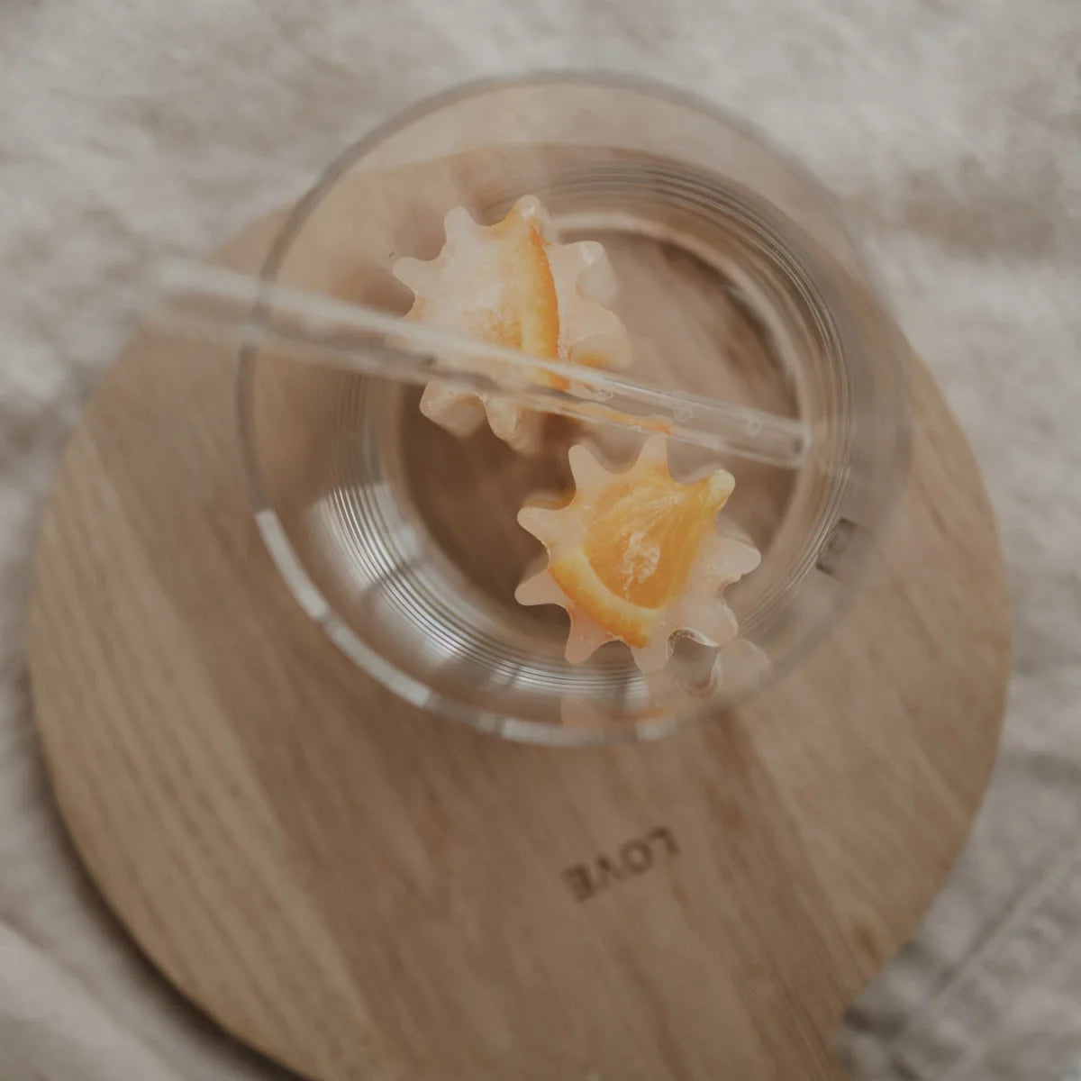 Klare Glas-Tumbler mit transparentem Strohhalm und schwimmenden Sternorangen | Eiswürfelform Blume grau