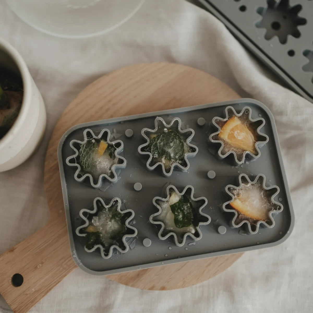 Graue Silikon-Eiswürfelform Blume mit sternförmigen Mulden, gefüllt mit Wasser und Gemüse