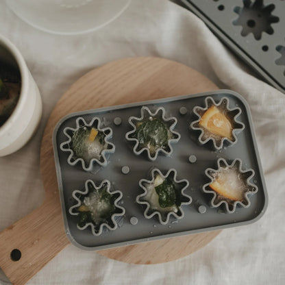 Graue Silikon-Eiswürfelform Blume mit sternförmigen Mulden, gefüllt mit Wasser und Gemüse