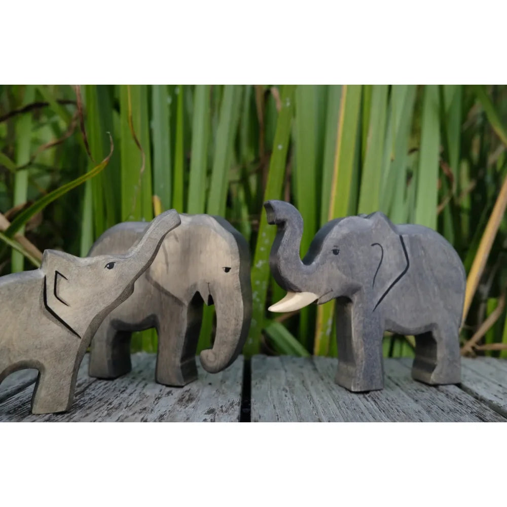 Drei geschnitzte Holz Elefanten, zwei hellgrau, einer dunkelgrau, mit erhobenem Rüssel