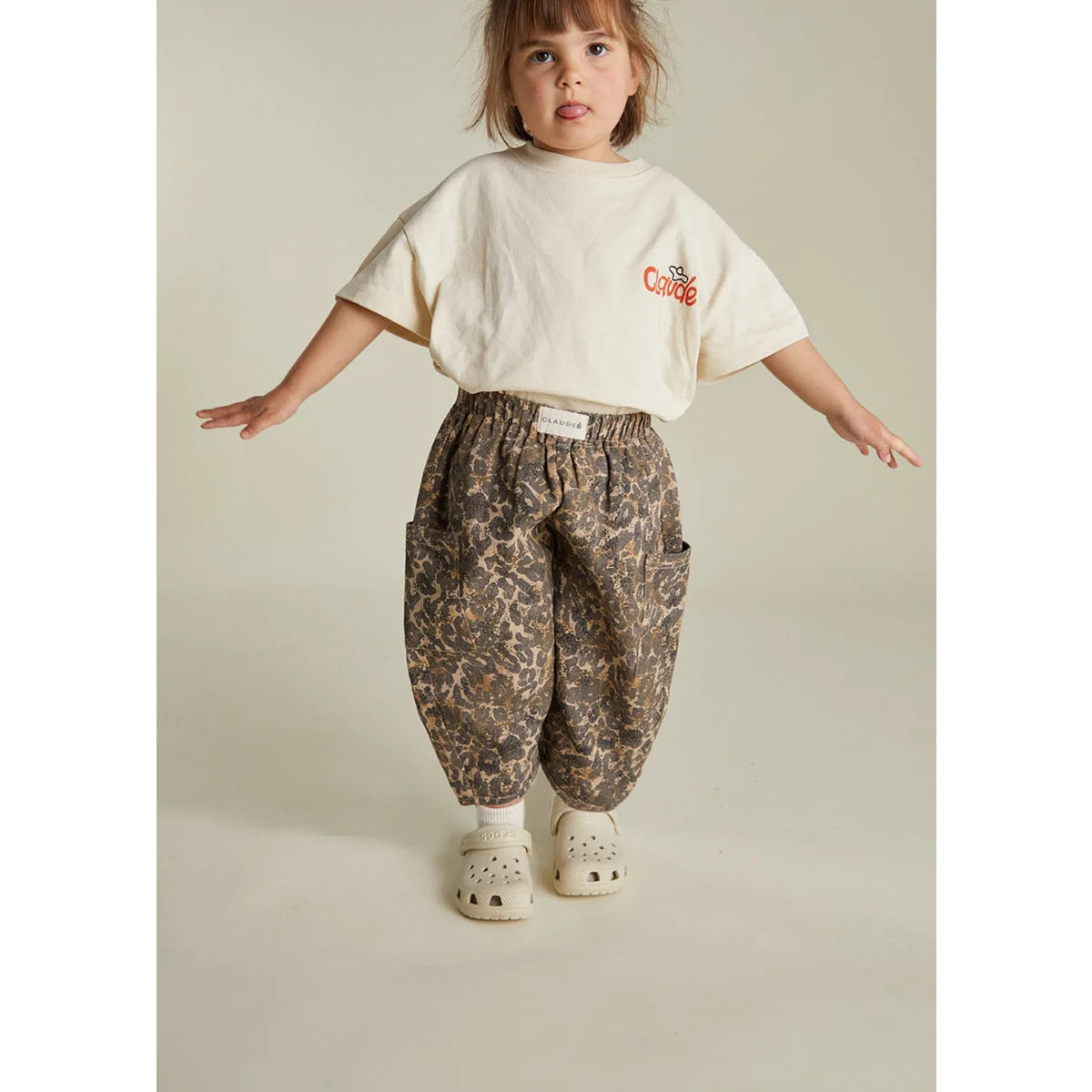 Kind bei Trage der Emerson Trouser Leo in Beige-Leopardmuster