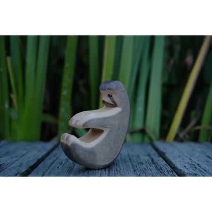 Handgeschnitzte Faultier-Figur aus Holz mit hellgrauer Oberfläche und Maserung