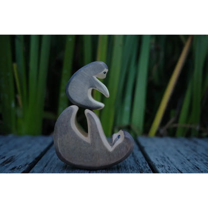 Graues Holz-Faultier klein mit kleinem Faultier obenauf, minimalistisch