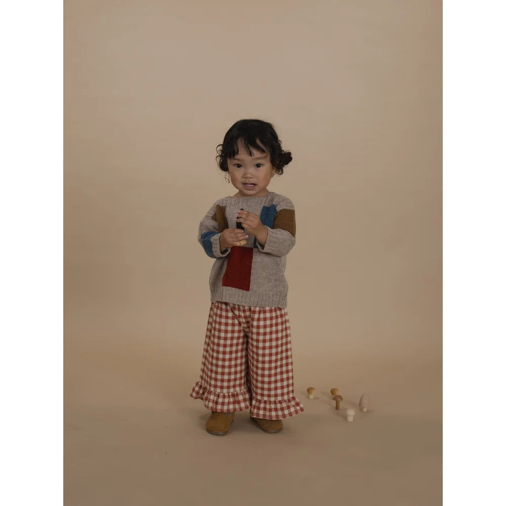 Kleinkind trägt Patchwork-Pullover und Gingham-Rüschenhose in Frill Culottes Paprika Gingham