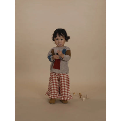 Kleinkind trägt Patchwork-Pullover und Gingham-Rüschenhose in Frill Culottes Paprika Gingham
