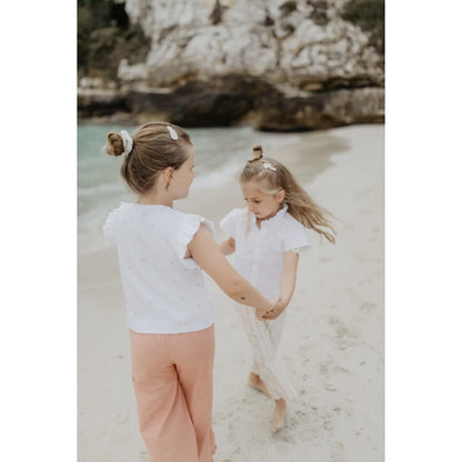 Zwei Mädchen in Frill Sleeve Top Hearts auf Sandstrand, viel Bewegungsfreiheit