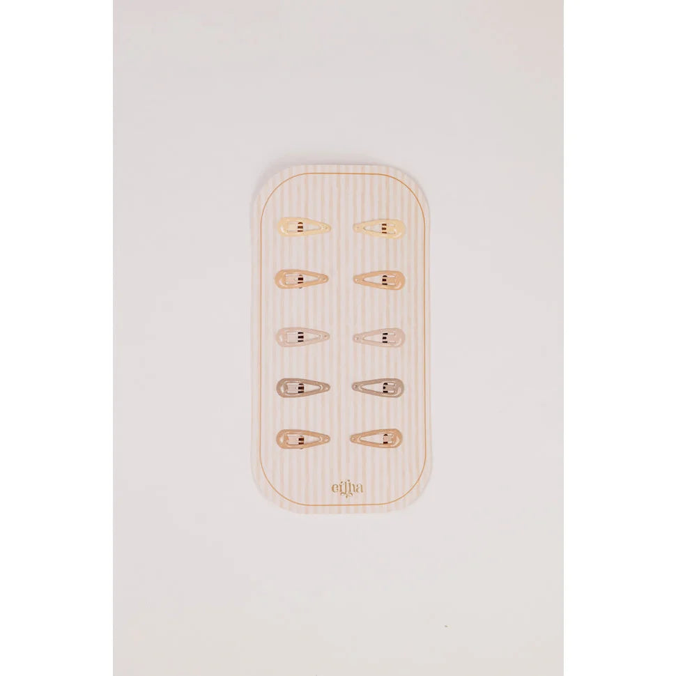 Glitzer Mini Haarklammern aus Gold und Silber auf Holzteller