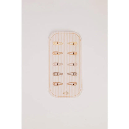 Glitzer Mini Haarklammern aus Gold und Silber auf Holzteller