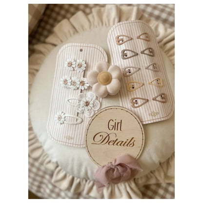 Weiße Blumen-Haarclips mit Perlen und Holzblütenzentrum auf gestreiftem Stoff