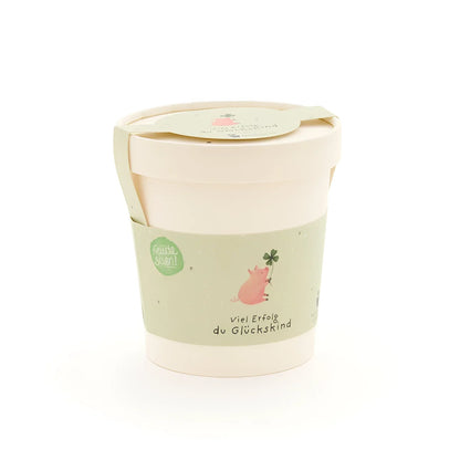Glückskind becher aus pastellgrünem und cremefarbenem papier mit süßem rosa schwein und vierblättrigem klee, ideal für ökologische baby- & kinderprodukte