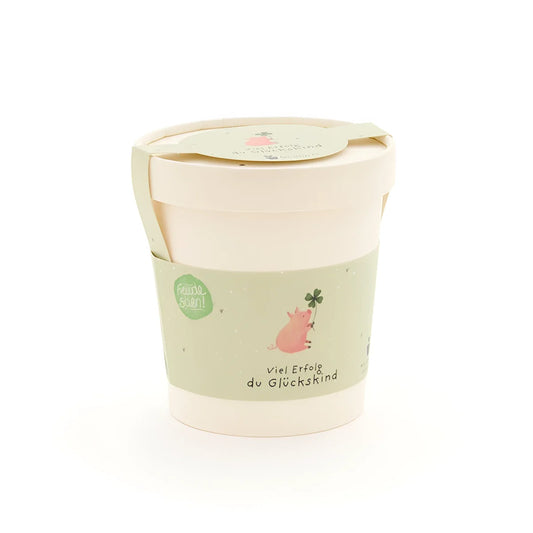 Glückskind becher aus pastellgrünem und cremefarbenem papier mit süßem rosa schwein und vierblättrigem klee, ideal für ökologische baby- & kinderprodukte