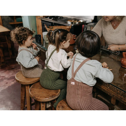 Drei junge Kinder sitzen auf Hockern am Tisch mit Granny Teddy Strumpfhose