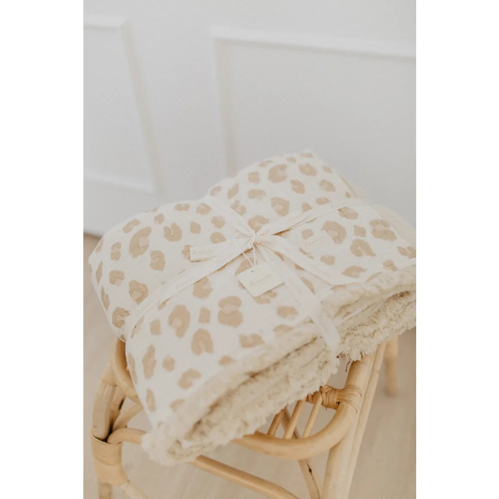 Gefaltete Tagesdecke mit Leoprint und cremefarbenem Band, passend zum Produkt Grosse Tagesdecke zum Wenden leoprint cappuccino