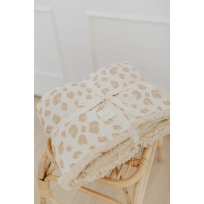 Gefaltete Tagesdecke mit Leoprint und cremefarbenem Band, passend zum Produkt Grosse Tagesdecke zum Wenden leoprint cappuccino