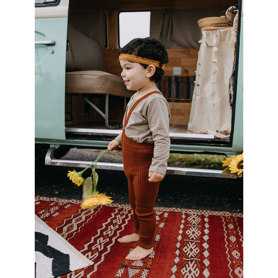 Kind nackte Strumpfhose mit Trägern in Zimt für Kinder, barfuß auf rotem Teppich