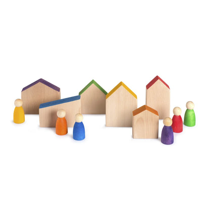 Ein set aus bunten holzspielzeughäusern und figuren mit bemalten dächern körpern und köpfen namens houses + nins