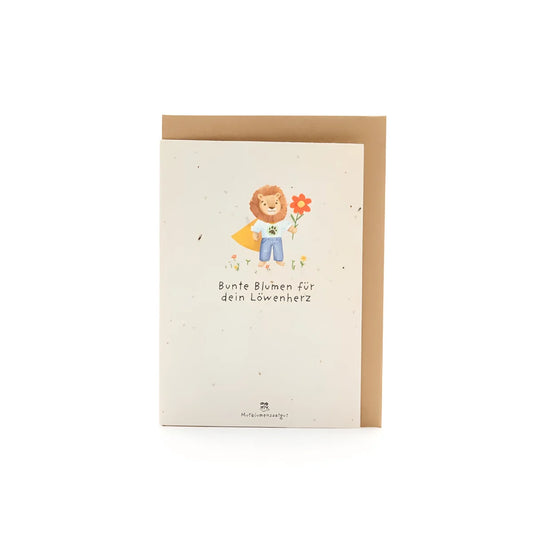 Karte back-to-school löwe aus nachhaltigem samenpapier mit blauem löwen und text bunte blumen für dein löwenherz als geschenke für neugeborene