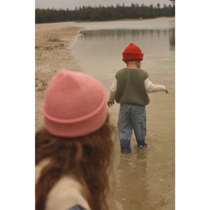 Kinder im roten und pinken Beanie spielen im flachen Wasser mit Kids Vest Harvey Artichoke