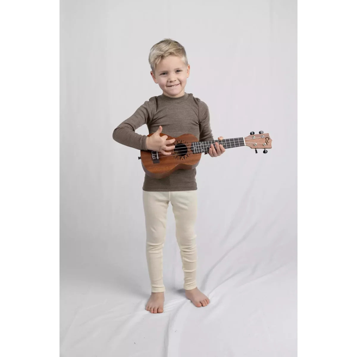 Kindern halten kleines braunes Holz-Ukulele, Kinder-Leggings natur