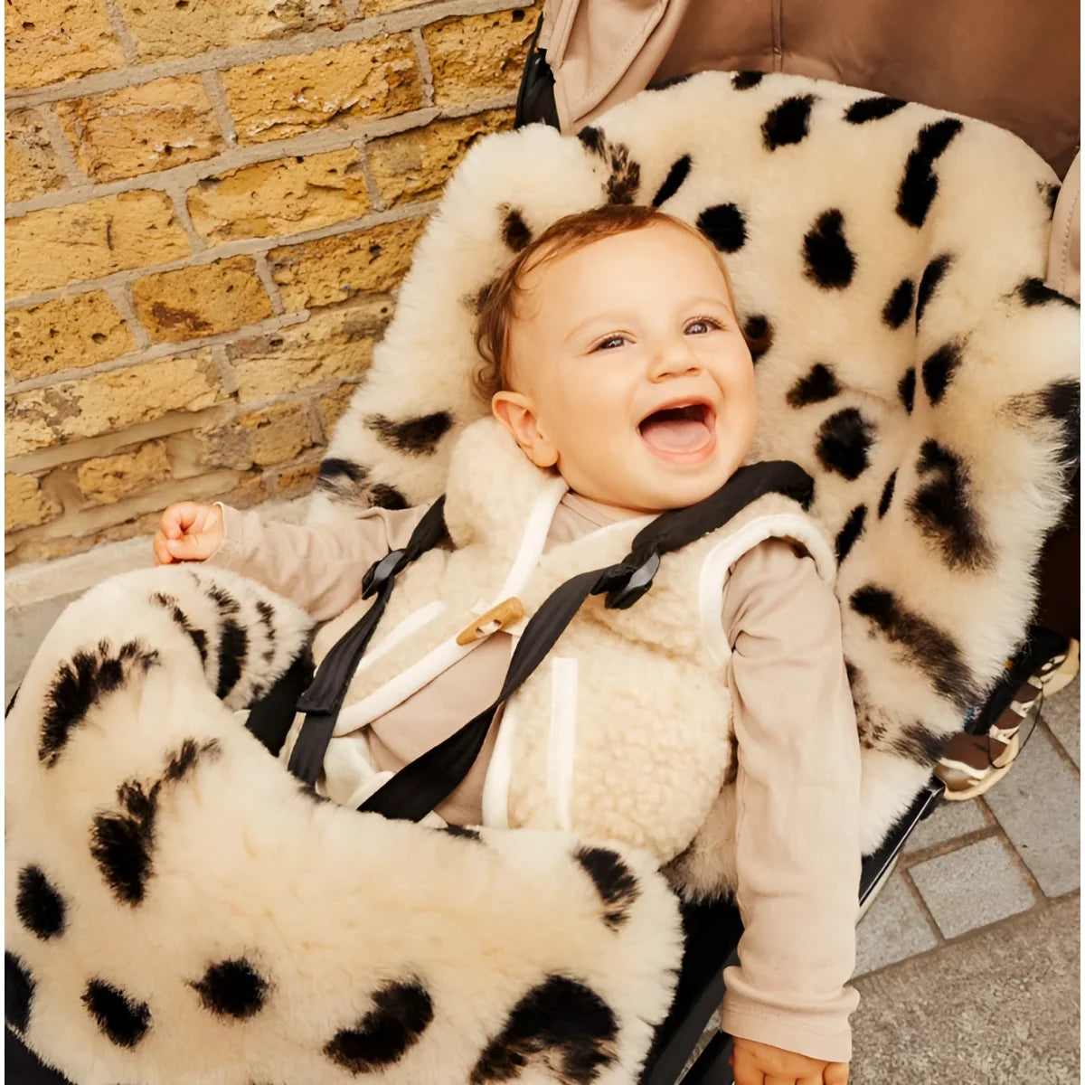 Glückliches Baby in Leopard Faux Fur Autositzbezug mit schwarzen Flecken