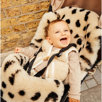 Glückliches Baby in Leopard Faux Fur Autositzbezug mit schwarzen Flecken