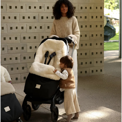 Schwarzer Kinderwagen-Fußsack Puffmuff mit weißem Plüschfutter und festem Geschirr